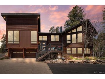 Stunning two-story home with wood siding, two-car garage, and picturesque front entrance at 8453 S Scenic Dr, Morrison, CO 80465