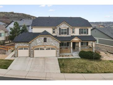 Charming two-story home with a three-car garage, stone accents, and a cozy front porch at 2463 Tavern Way, Castle Rock, CO 80104