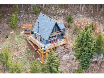 Charming A-frame cabin with an expansive deck nestled in a serene mountain setting with a hot tub at 352 Apache Rd, Evergreen, CO 80439