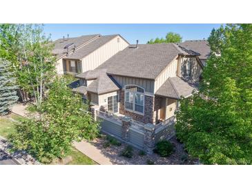Charming townhome with stone accents, a private balcony, and lush landscaping at 3985 W 104Th Dr # E, Westminster, CO 80031
