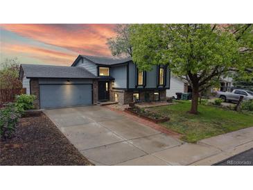 Charming two-story home featuring a well-maintained front yard and attached two-car garage with beautiful sunset at 10759 Clermont St, Thornton, CO 80233