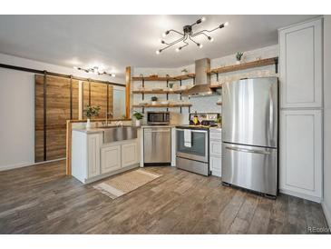 Modern kitchen features stainless appliances, floating shelves, and stylish lighting fixtures at 1625 Larimer St # 3004, Denver, CO 80202