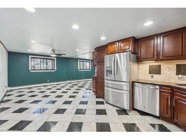 Spacious kitchen features stainless steel appliances, dark wood cabinetry, and black and white tiled floor at 8822 E Florida Ave # G07, Denver, CO 80247