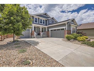 Charming two-story home with a three-car garage, landscaped front yard, and a concrete driveway at 9527 Iron Mountain Way, Arvada, CO 80007