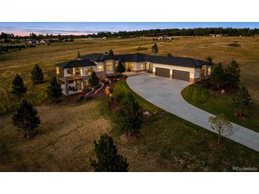 Stunning aerial view of modern home with landscaped yard and circular driveway at dusk at 2937 Hidden Den Ct, Franktown, CO 80116