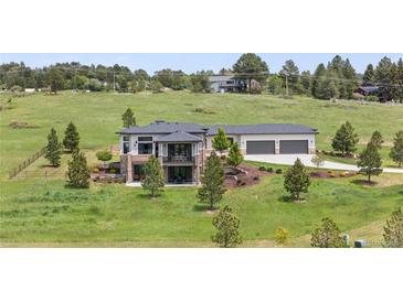Beautiful two-story home with stone accents, three-car garage, balcony and professional landscaping at 2937 Hidden Den Ct, Franktown, CO 80116