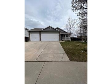 Charming home featuring a two-car garage, landscaped front yard, and a welcoming front porch at 2242 S Uravan St, Aurora, CO 80013