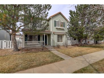 Charming two-story home featuring a cozy front porch and a well-maintained, landscaped front yard at 4673 Perth St, Denver, CO 80249
