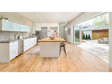 Bright, open kitchen featuring a butcher block island, stainless steel appliances, and seamless indoor/outdoor flow at 1452 S Washington St, Denver, CO 80210
