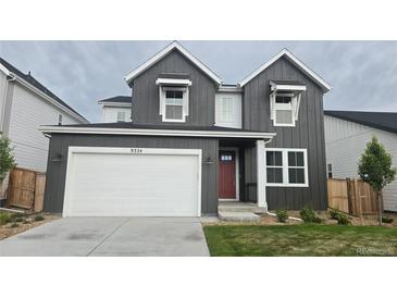 Charming two-story home featuring vertical siding, a red front door, and a pristine white garage door at 9324 Quartz St, Arvada, CO 80007