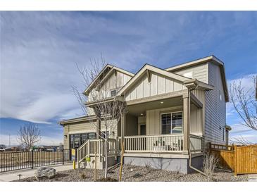 Inviting two-story home featuring a charming front porch and neutral-toned siding, complemented by well-maintained landscaping at 4108 Estrella St, Brighton, CO 80601