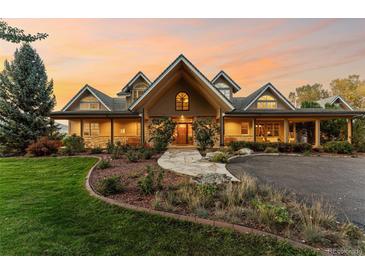 Inviting two-story home with lush landscaping, stone pathway, and covered porch at 5101 Saint Vrain Rd, Longmont, CO 80503