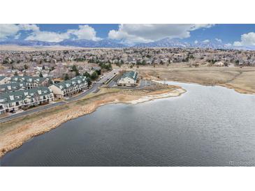 Aerial view of townhome community with pond, landscaping, and parking near walking trails at 1825 Spaulding Cir, Superior, CO 80027