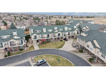 Aerial view showcasing townhouse with green roof, private patios, and manicured landscaping in a quiet neighborhood setting at 1825 Spaulding Cir, Superior, CO 80027