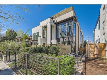 Modern two-story home with a combination of white stone and wood-paneled accents at 427 Milwaukee St, Denver, CO 80206