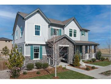 Charming two-story home featuring stone accents, gray siding, green shutters, and a welcoming front porch at 5788 N Killarney Way, Aurora, CO 80019