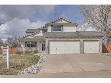 Inviting two-story home featuring a three-car garage, manicured lawn, and charming front porch at 23709 Glenmoor Dr, Parker, CO 80138