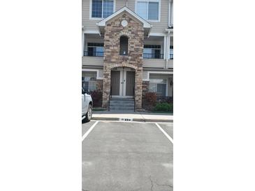 Attractive condo entrance featuring stone archway and well-maintained landscaping at 12711 Colorado Blvd # 1116, Thornton, CO 80241