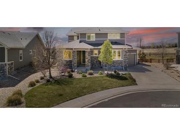 Beautiful two-story home featuring stone accents, manicured lawn, and a welcoming covered porch at 4220 Kestrel Dr, Broomfield, CO 80023