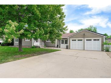 Charming single-story home with a well-manicured lawn, mature shade tree, and an attached two-car garage at 8525 Grandview Ave, Arvada, CO 80002