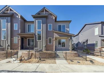 Modern two-story townhouse showcasing a stylish exterior with a combination of siding and brick accents at 468 Millwall Cir, Castle Pines, CO 80108