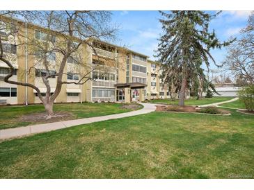 Inviting apartment building with well-maintained landscaping and mature trees against a blue sky backdrop at 720 S Clinton St # 1B, Denver, CO 80247