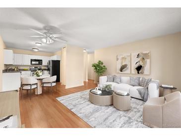Bright living room featuring hardwood floors, a white sofa set, and stylish decor at 720 S Clinton St # 1B, Denver, CO 80247
