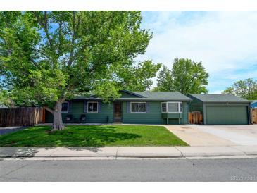 Charming home with green exterior, mature trees, and a well-manicured lawn creates a welcoming curb appeal at 5986 Dunraven St, Golden, CO 80403