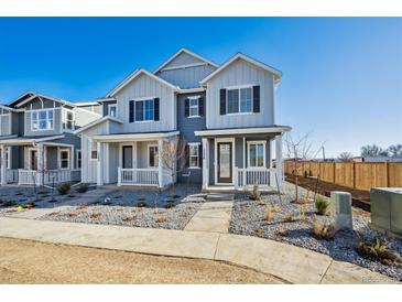 Charming two-story home showcasing a covered front porch, modern design and manicured landscaping at 1238 Penner Dr, Erie, CO 80026