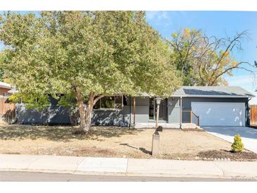 Ranch style home with gray exterior, landscaped yard, and attached garage at 34 University Dr, Longmont, CO 80503