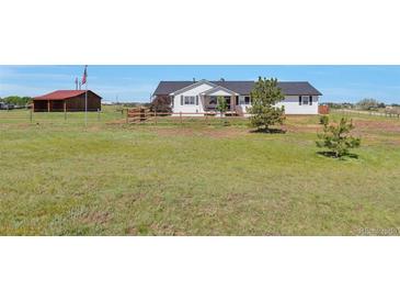 Charming single-story home with a covered front porch and a spacious grassy front yard at 1740 Territory Cir, Parker, CO 80138