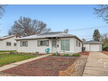 Charming single-story home featuring a well-maintained yard and detached garage at 1011 Uvalda St, Aurora, CO 80011