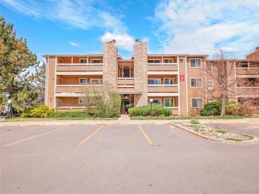 Condominium exterior featuring stone accents and well-maintained landscaping on a partly cloudy day at 1094 S Dearborn St # 301, Aurora, CO 80012
