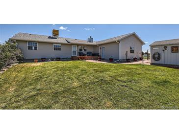 Well-manicured backyard featuring a spacious lawn, deck, and storage shed perfect for outdoor living at 7716 Shenandoah Dr, Elizabeth, CO 80107