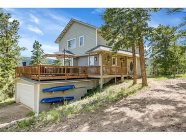 Charming two-story home featuring a spacious deck, garage, and kayaks, nestled in a natural setting at 6979 Weasel Way, Evergreen, CO 80439