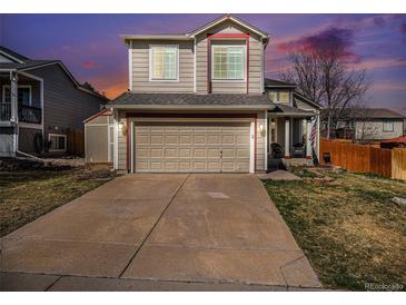 Charming two-story home with a well-maintained lawn and a two-car garage at 16277 Blueleaf Pl, Parker, CO 80134