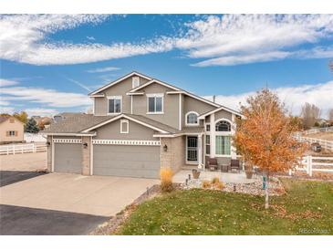 Two-story house with a three-car garage and landscaped yard at 16351 Umpire St, Hudson, CO 80642