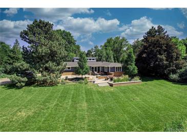 Expansive backyard view, featuring patio seating and lush landscaping at 5350 Yellowstone St, Bow Mar, CO 80123