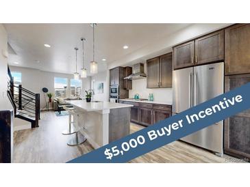 Modern kitchen with stainless steel appliances, a large island, and stylish pendant lighting fixture at 8742 E 47Th Ave, Denver, CO 80238