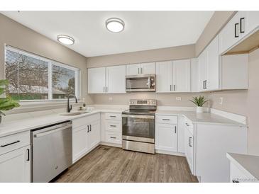 Modern kitchen features white cabinets, stainless steel appliances, and quartz countertops at 16038 E Oxford Dr, Aurora, CO 80013