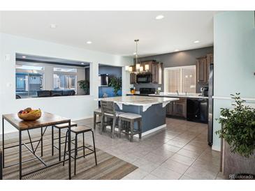 Charming kitchen featuring a large marble island, modern lighting, tile floor, and stainless steel appliances at 20054 E 48Th Dr, Denver, CO 80249
