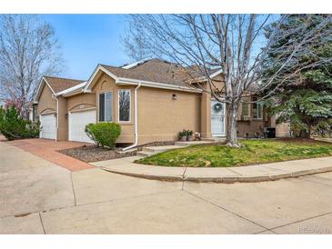 Charming townhome featuring a well-maintained lawn and attached two-car garage at 12610 E Wesley Pl, Aurora, CO 80014