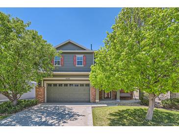 Charming two-story home featuring a two-car garage, red shutters, and mature trees in a well-maintained neighborhood at 14183 Madison Way, Thornton, CO 80602