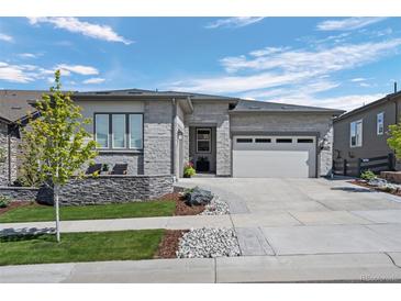 Beautiful single-story home with stone facade, manicured lawn, and attached two-car garage at 2144 Bellcove Dr, Castle Pines, CO 80108