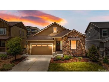 Charming single-Gathering home with a stone facade, a two-car garage, and a well-manicured lawn at 9781 Eagle River St, Littleton, CO 80125