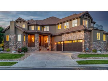 Stunning two-story home with a stone facade, a circular driveway, and a three-car garage at 15501 Fairway Dr, Commerce City, CO 80022