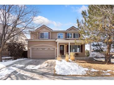 Charming two-story home with a well-manicured front yard and an attached two-car garage at 9847 Helena Ct, Commerce City, CO 80022