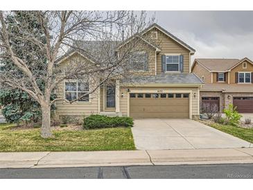 Two-story home featuring a tan exterior, a two-car garage, and a well-maintained front yard at 6172 S Salida Ct, Aurora, CO 80016