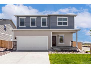 Charming two-story home with a well-manicured lawn, two car garage and inviting front porch at 48220 Shetland Dr, Bennett, CO 80102