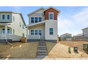 Charming two-story home featuring varied siding, inviting front porch, and meticulous landscaping at 5928 N Lisbon St, Aurora, CO 80019